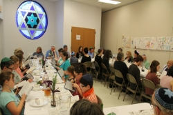 People sitting in a synagogue for the congregations Yom HaShoah ceremony 